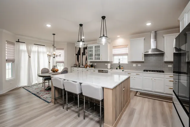 a kitchen with appliances a sink a center island and cabinets