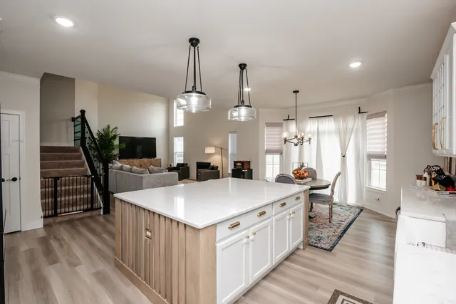 a large kitchen with kitchen island a stove a sink a center island and couches