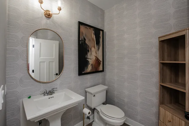 a bathroom with a toilet a sink and mirror