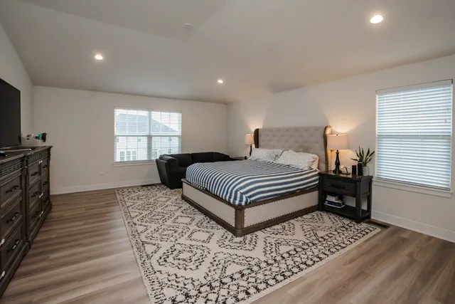 a bedroom with a bed and wooden floor