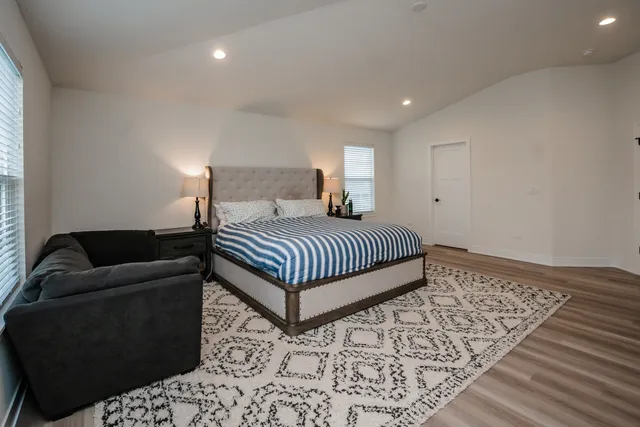 a bedroom with a bed rug and wooden floor
