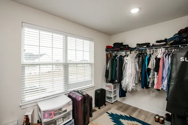 a view of walk in closet with clothes