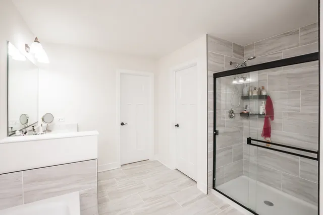 a bathroom with a sink mirror and shower