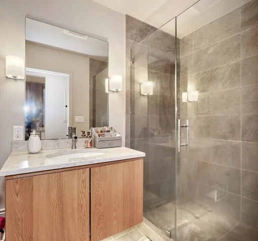a bathroom with a double vanity sink mirror and shower