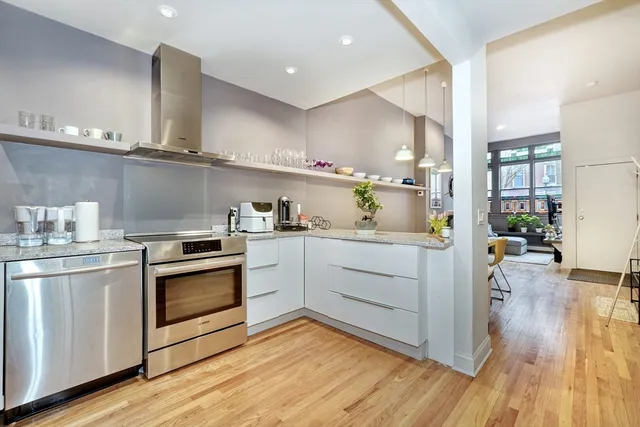 a kitchen with cabinets wooden floor and stainless steel appliances