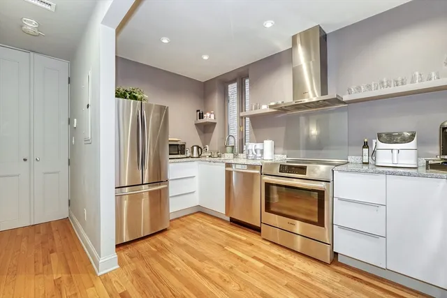 a kitchen with white cabinets and stainless steel appliances