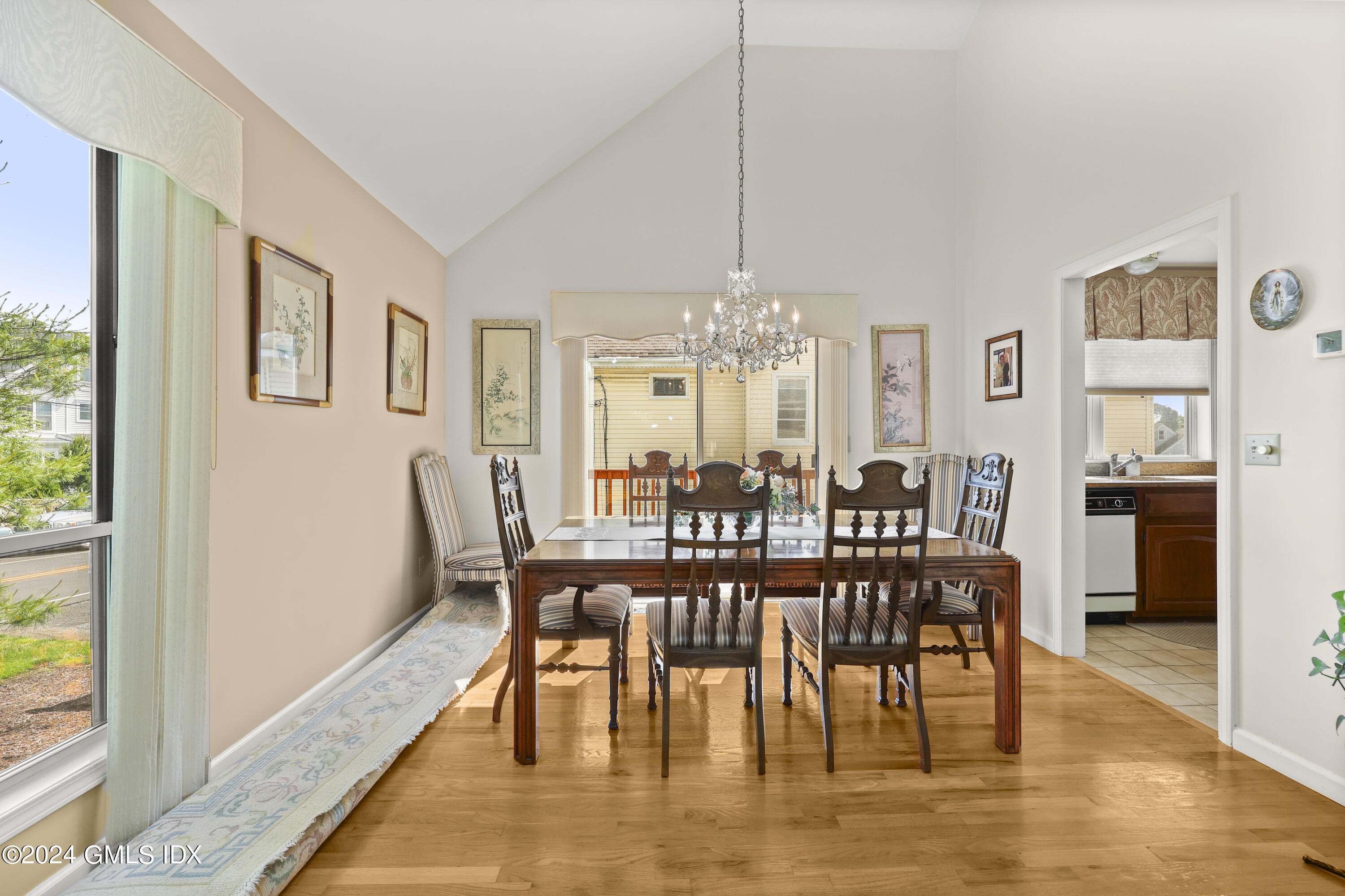 162 Colonial Road, Unit 12 Stamford, CT 06906 - Photo 8 of 38 a dining room with furniture a chandelier and wooden floor