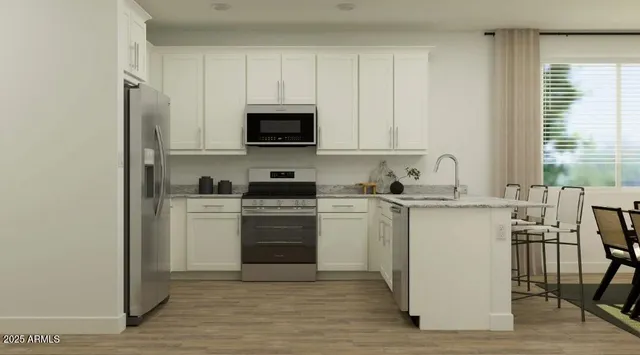 a kitchen with appliances a sink and cabinets