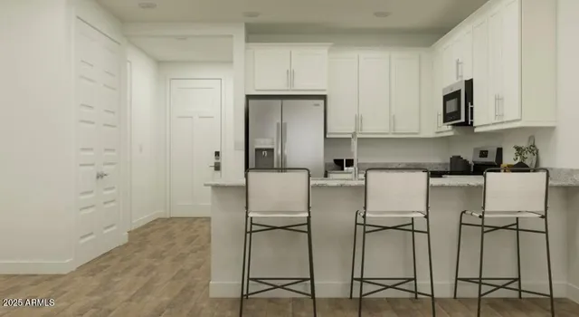 a kitchen with cabinets and chairs