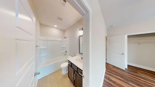 a bathroom with a bathtub shower sink vanity and toilet