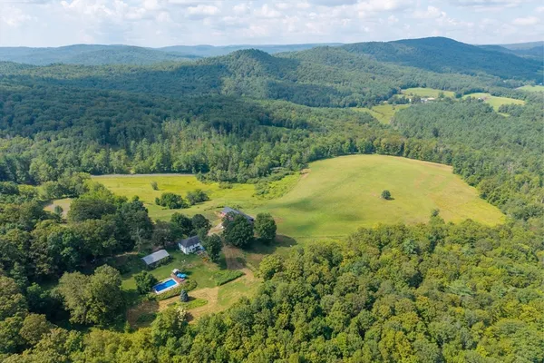 an aerial view of mountain with residential house in background