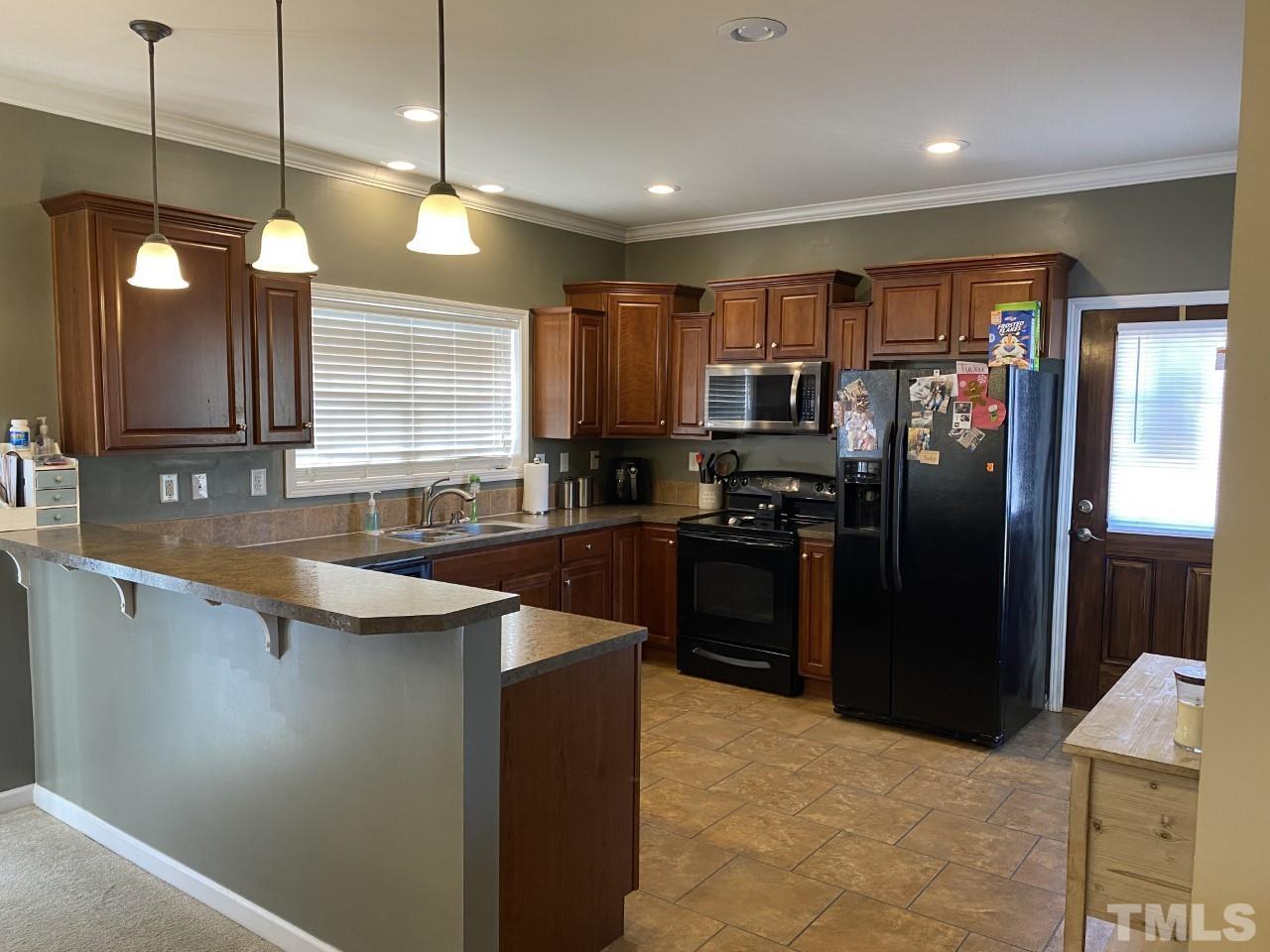 274 South Chaucer Way Kittrell, NC 27544 - Photo 6 of 28 a kitchen with stainless steel appliances granite countertop a refrigerator a sink a stove and wooden cabinets