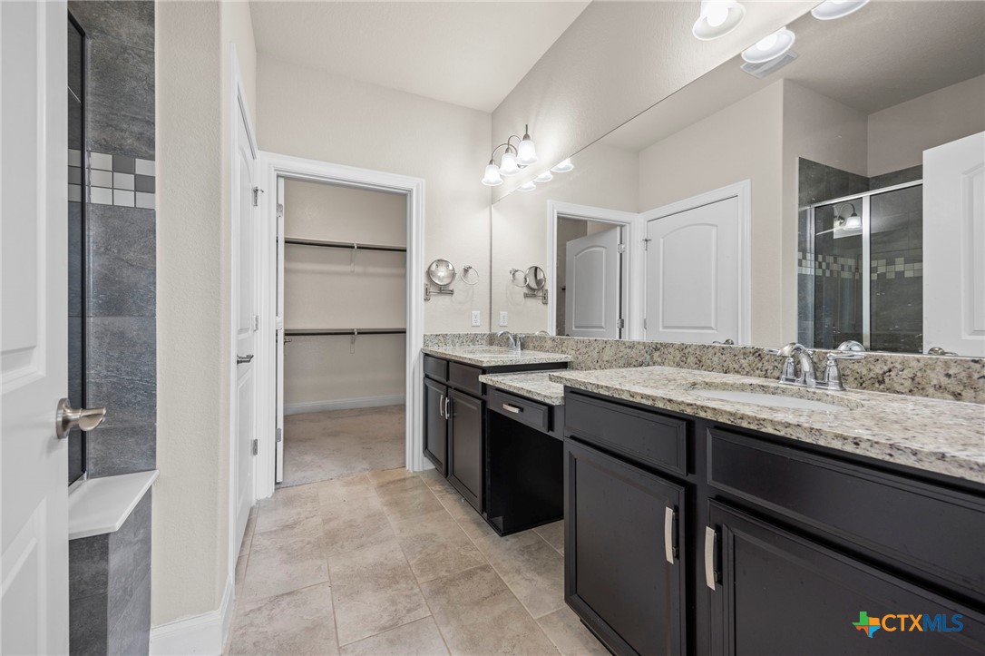 18215 Winnow Way Pflugerville, TX 78660 - Photo 17 of 21 a bathroom with a granite countertop sink two mirror and a refrigerator