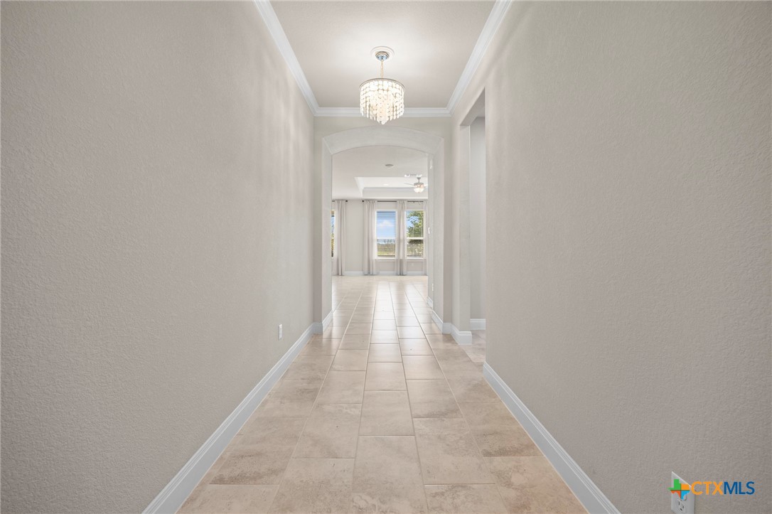 18215 Winnow Way Pflugerville, TX 78660 - Photo 3 of 21 a view of a hallway with wooden floor and a chandelier