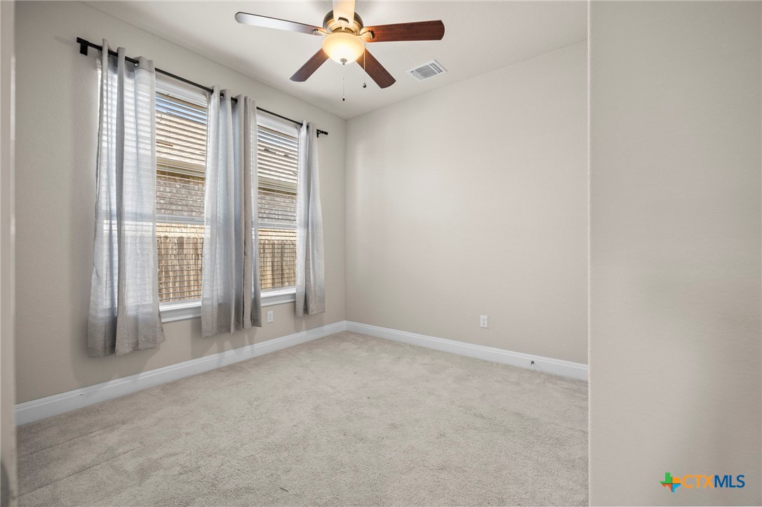 18215 Winnow Way Pflugerville, TX 78660 - Photo 5 of 21 an empty room with windows and fan