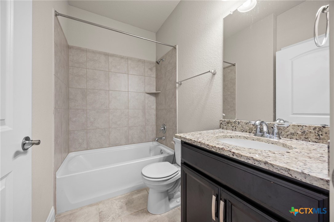 18215 Winnow Way Pflugerville, TX 78660 - Photo 7 of 21 a bathroom with a granite countertop bathtub sink vanity mirror and toilet