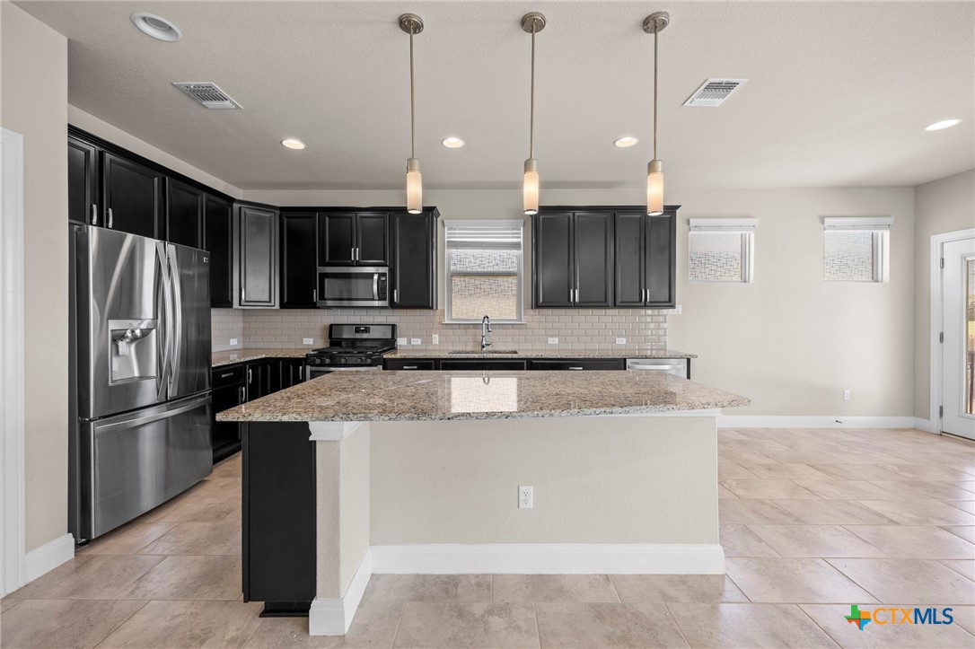 18215 Winnow Way Pflugerville, TX 78660 - Photo 10 of 21 a kitchen with stainless steel appliances granite countertop a refrigerator a sink a stove and a oven