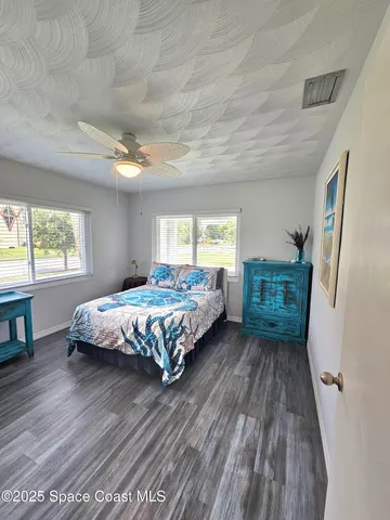 a bedroom with a bed wooden floor and window