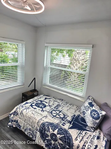 a bed sitting in a bedroom next to a window