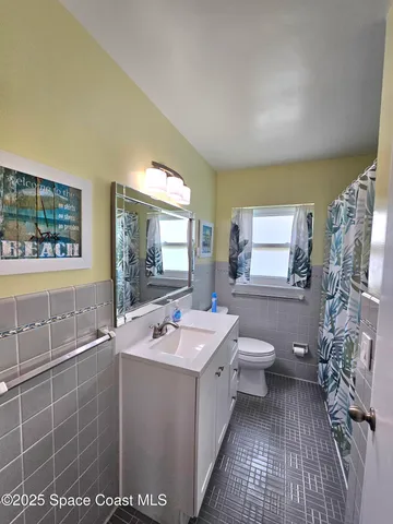 a bathroom with a sink toilet and window