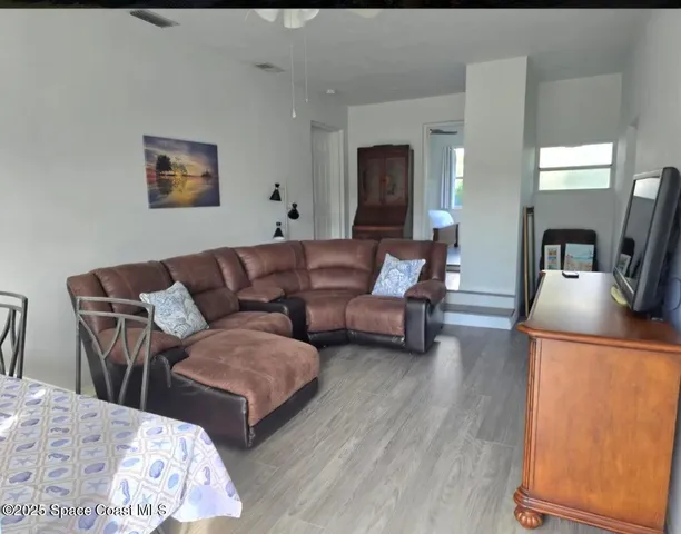 a living room with couches and painting on the wall