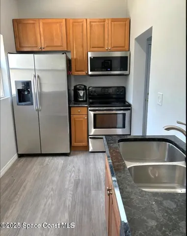 a kitchen with granite countertop a refrigerator and a stove