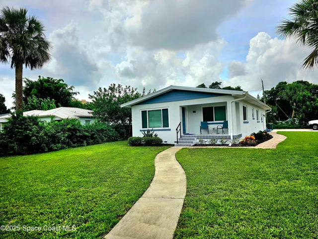 a view of a house with backyard sitting area and garden