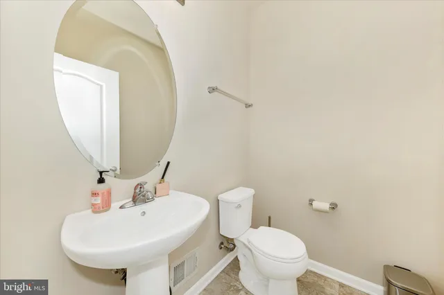 a bathroom with a sink a toilet and mirror