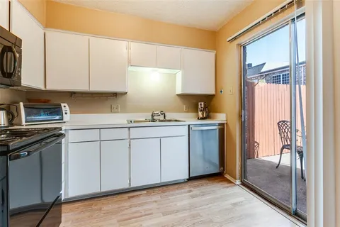 a kitchen with a sink cabinets stainless steel appliances and a window