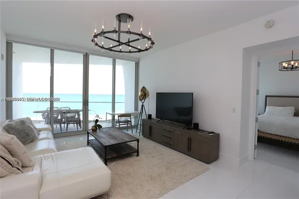 a living room with furniture a flat screen tv and kitchen view