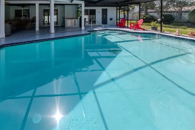 an aerial view of a residential houses with outdoor space and trees