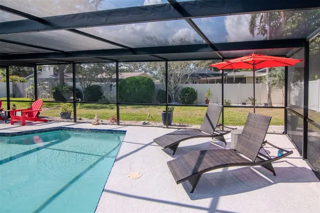 an aerial view of residential house with swimming pool and green space