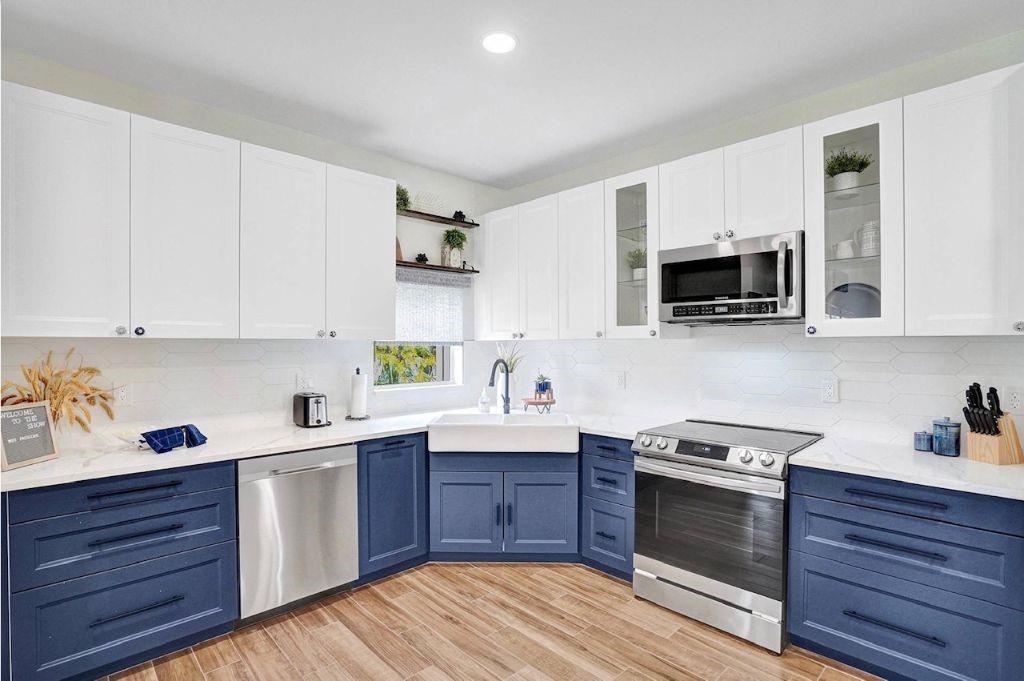 2622 Northeast 27th Avenue Lighthouse Point, FL 33064 - Photo 6 of 24 a kitchen with stainless steel appliances sink stove microwave and cabinets