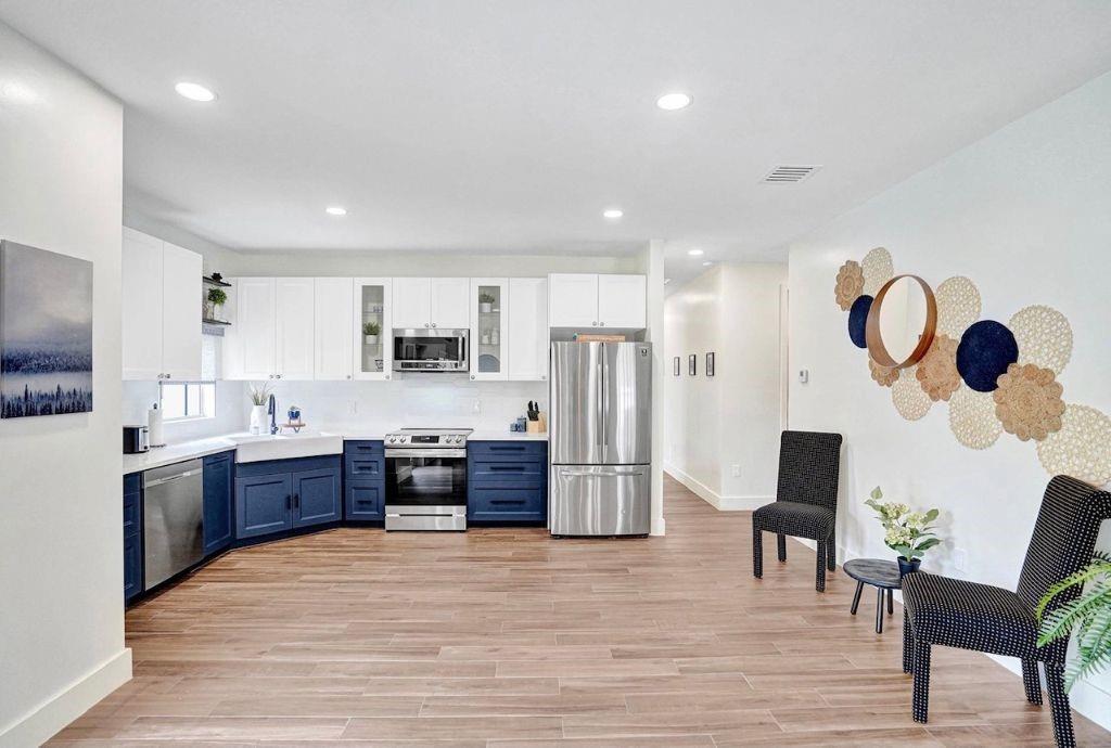 2622 Northeast 27th Avenue Lighthouse Point, FL 33064 - Photo 8 of 24 a large kitchen with stainless steel appliances granite countertop a refrigerator and a stove top oven with wooden floor