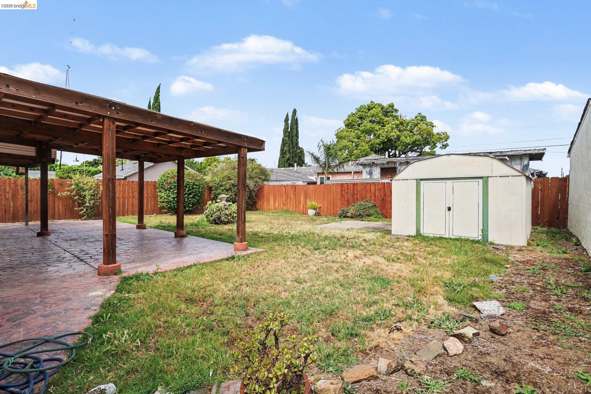 249 Madison Avenue Bay Point, CA 94565 - Photo 15 of 18 Expansive backyard with a covered patio featuring a wood beam pergola and a concrete patio