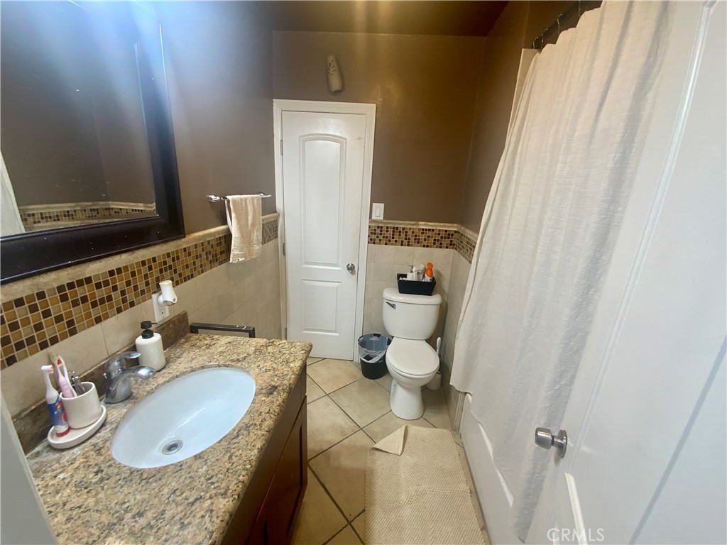 206 East Raymond Street Compton, CA 90220 - Photo 10 of 12 a bathroom with a granite countertop sink and a mirror
