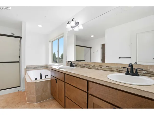 a bathroom with a sink double vanity granite and a bathtub