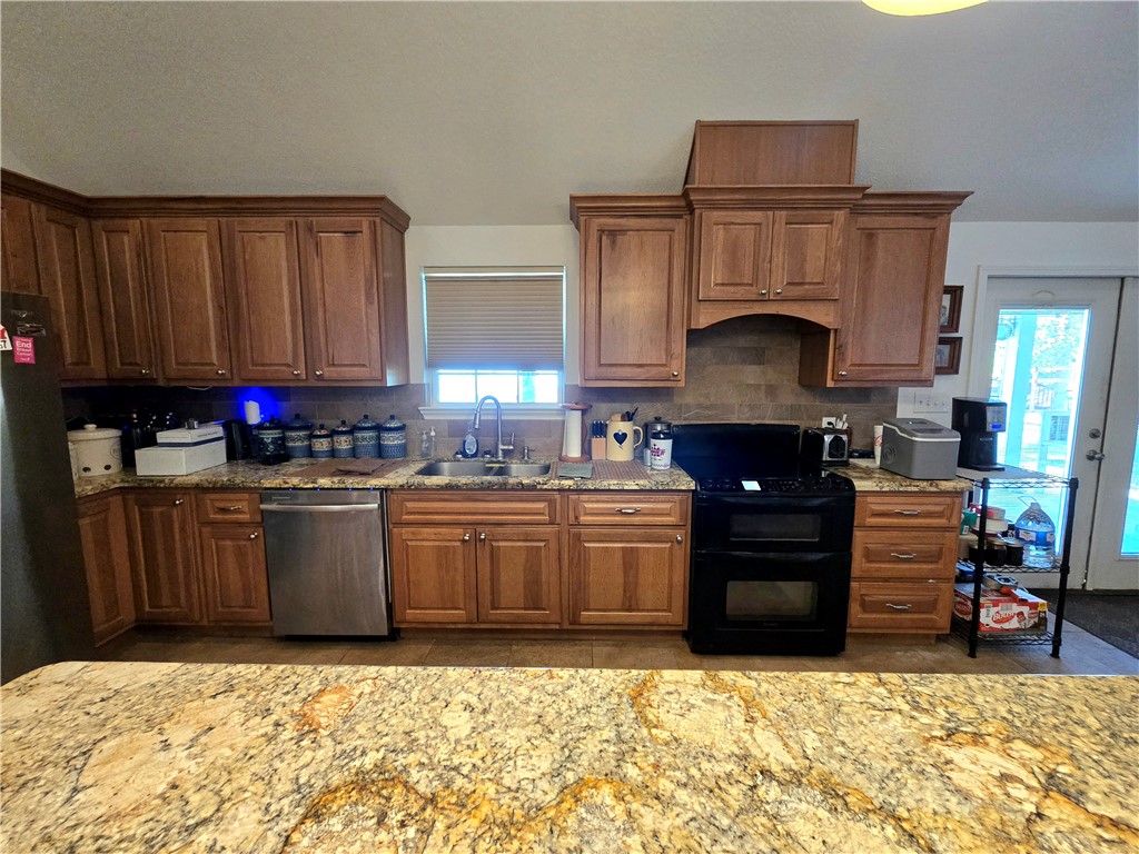 402 Shadow Arbor Circle Somerville, TX 77879 - Photo 11 of 26 a kitchen with stainless steel appliances kitchen island granite countertop a refrigerator stove and sink