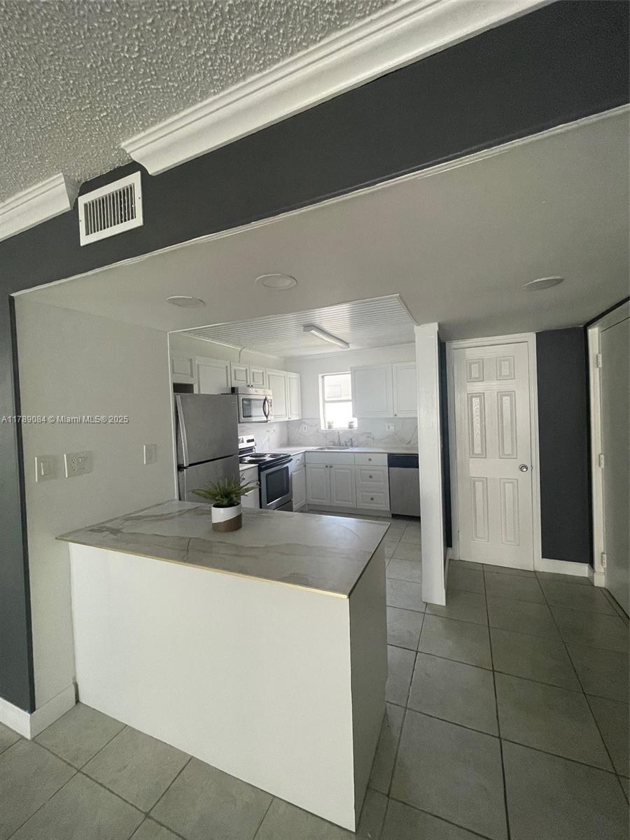 600 Northeast 25th Street, Unit 60 Miami, FL 33137 - Photo 3 of 10 a kitchen with a sink dishwasher and a refrigerator