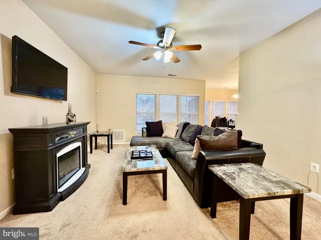 a living room with furniture a flat screen tv and a window