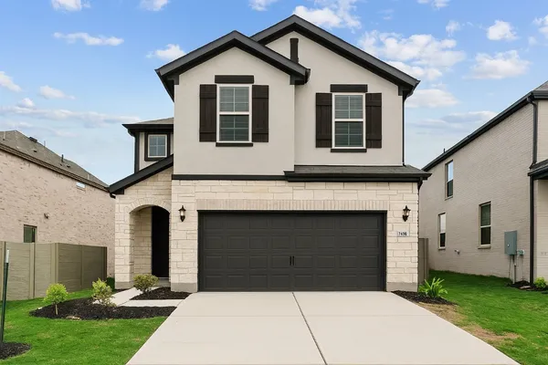 a front view of a house with a yard and garage