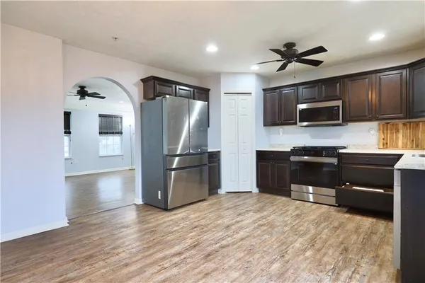 a kitchen with stainless steel appliances kitchen island granite countertop a refrigerator and a stove top oven