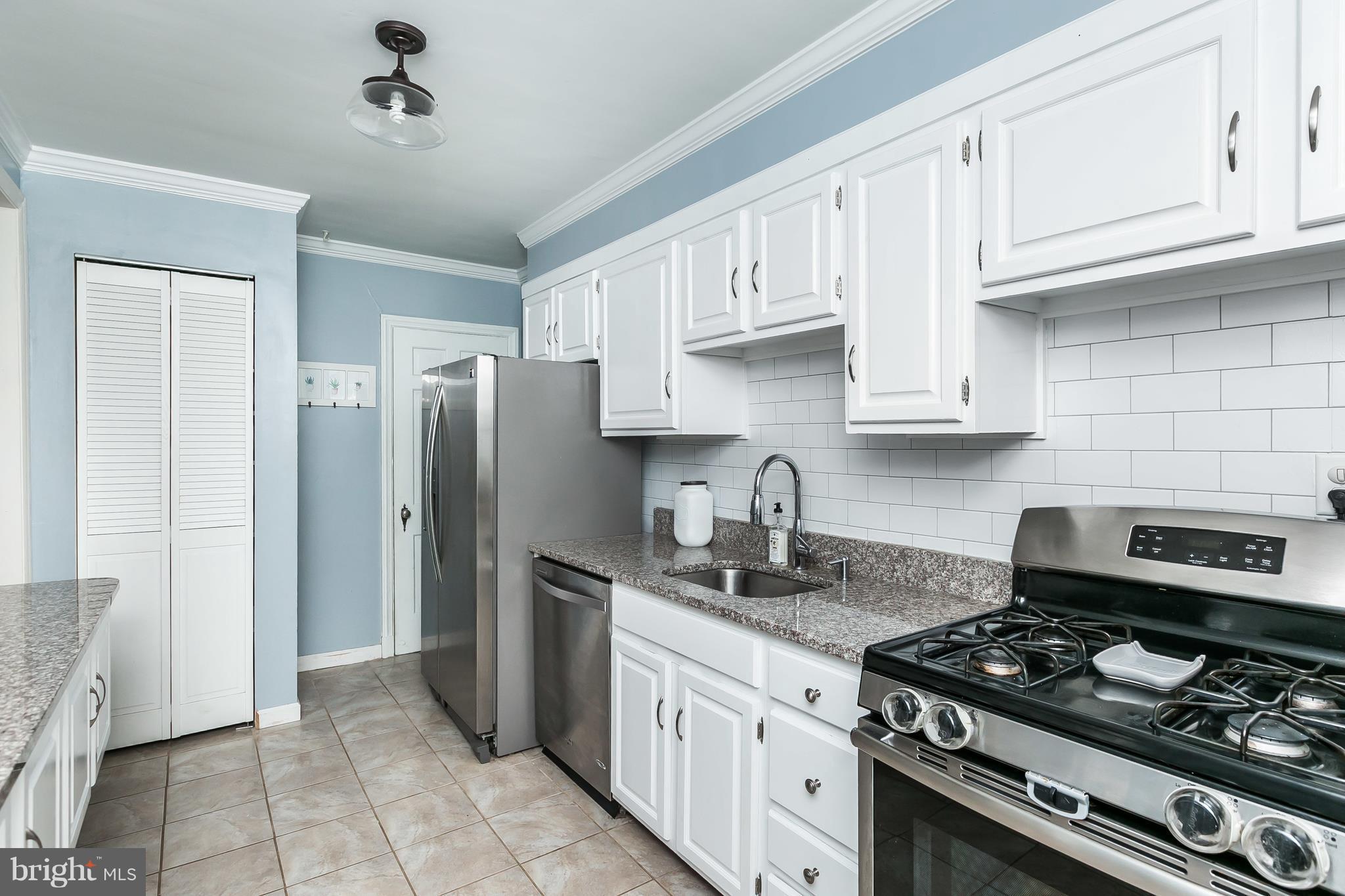 362 Greenlow Road Baltimore, MD 21228 - Photo 11 of 30 a kitchen with stainless steel appliances granite countertop a stove a refrigerator and a white cabinets