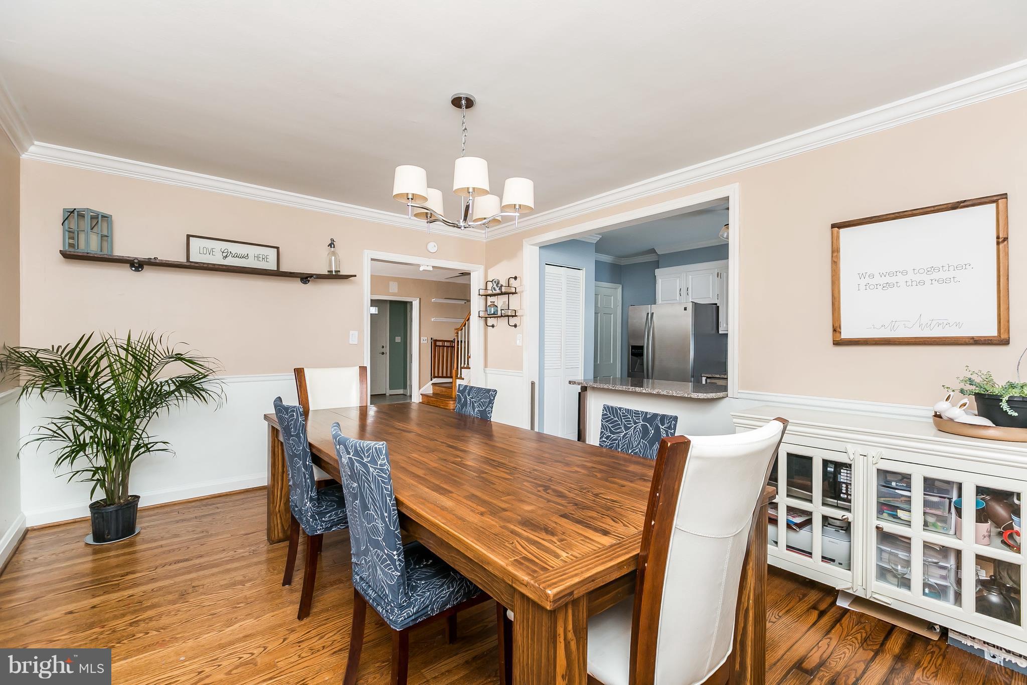 362 Greenlow Road Baltimore, MD 21228 - Photo 8 of 30 a dining room with wooden floor a chandelier a wooden table and chairs