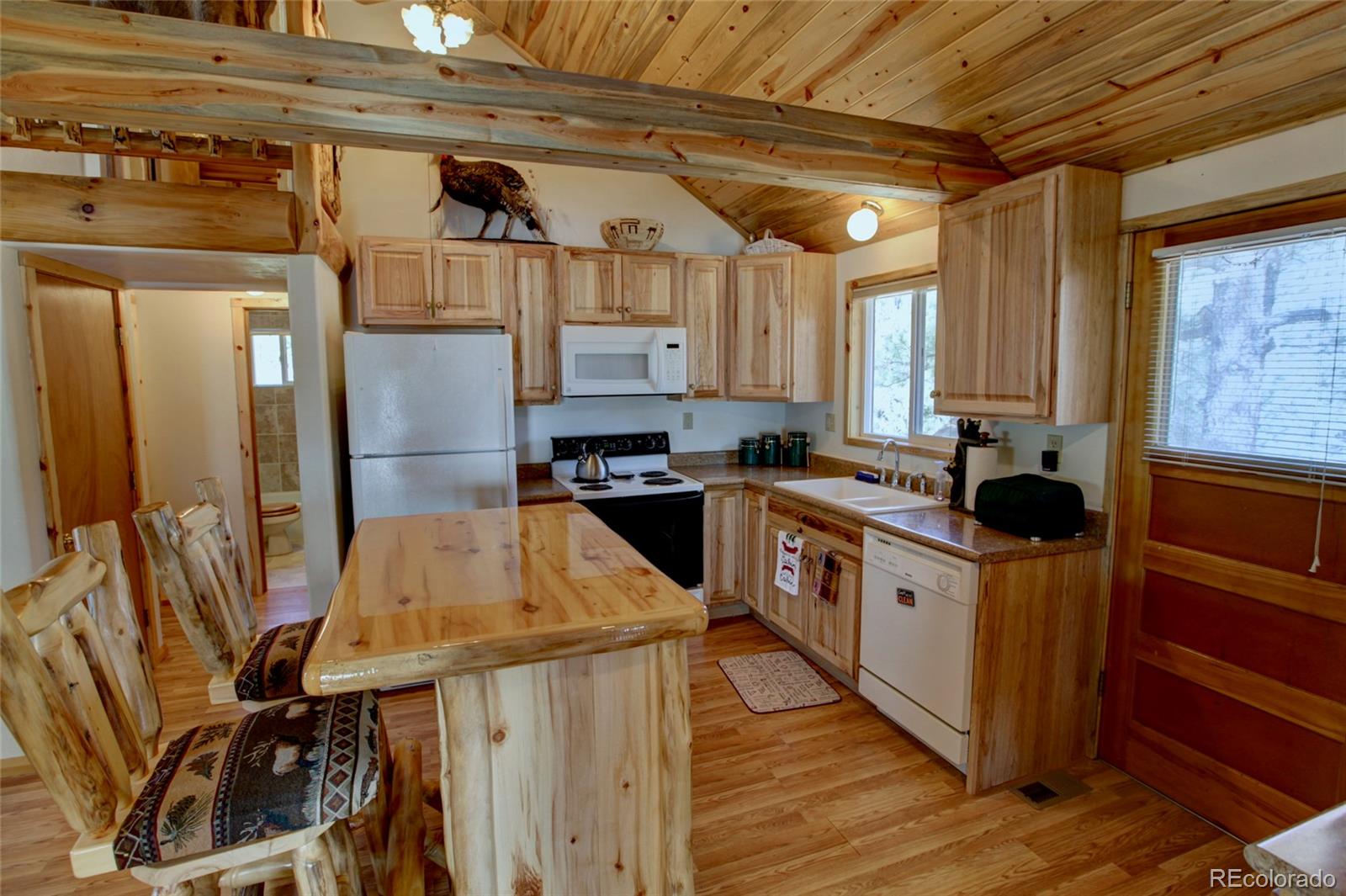 530 Red Feather Road Cotopaxi, CO 81223 - Photo 12 of 46 a kitchen with stainless steel appliances kitchen island granite countertop a table chairs in it and wooden floors