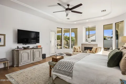 a bedroom with a bed television window and a flat screen television