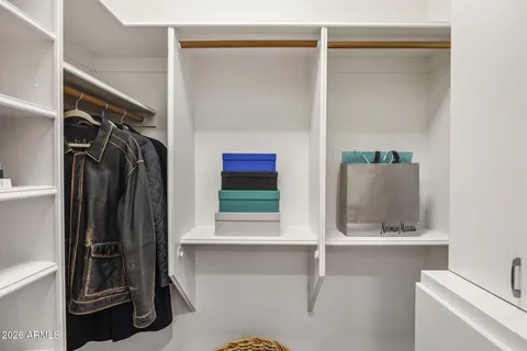 a view of walk in closet with clothes and shoes