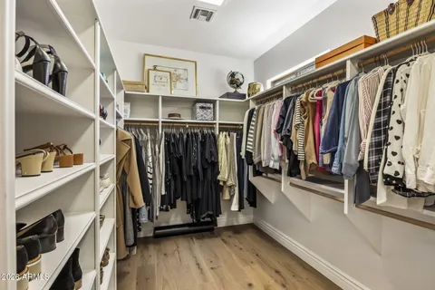 a view of walk in closet with clothes and shoes