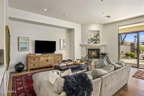 a living room with furniture a flat screen tv and a fireplace