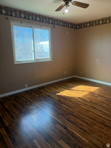 1259 West Raintree Drive Price, UT 84501 - Photo 3 of 10 Empty room with dark wood-type flooring and a ceiling fan